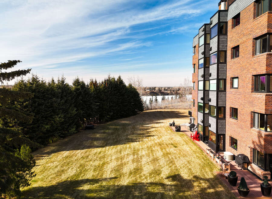 This stunning property boasts a modern architectural design with a brick facade and large windows, offering ample natural light.