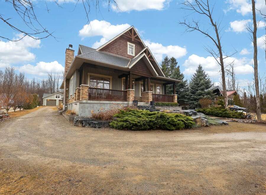 This stunning property boasts a charming exterior with a blend of natural materials and a welcoming porch.