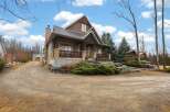This stunning property boasts a charming exterior with a blend of natural materials and a welcoming porch.