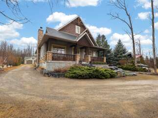 This stunning property boasts a charming exterior with a blend of natural materials and a welcoming porch.