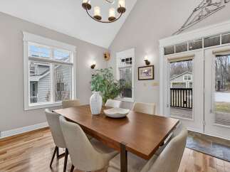 This stunning dining room features a modern wooden table, perfect for hosting gatherings.
