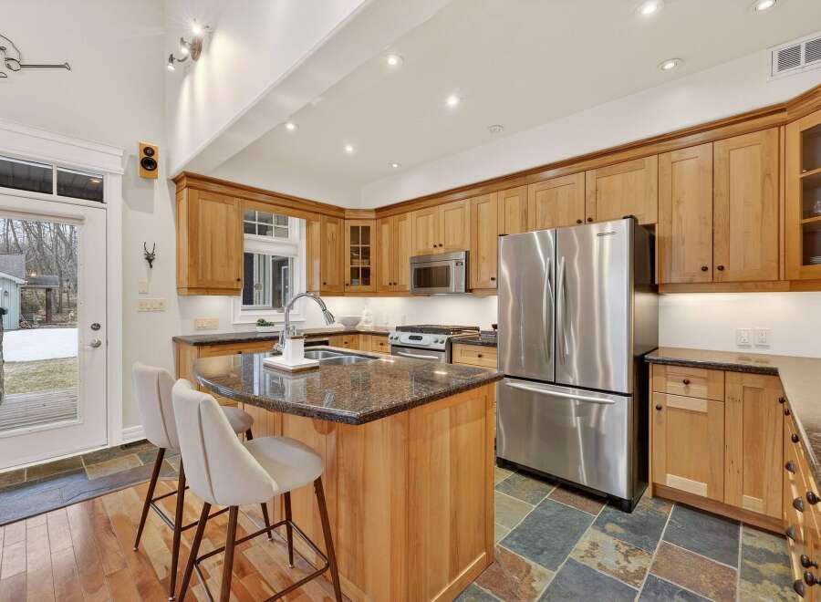 This stunning kitchen boasts custom cabinetry, a spacious island with seating, and high-end stainless steel appliances.