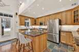 This stunning kitchen boasts custom cabinetry, a spacious island with seating, and high-end stainless steel appliances.