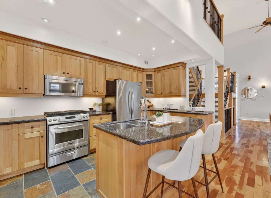 This stunning kitchen boasts beautiful wooden cabinetry and a spacious island with seating, perfect for entertaining.