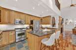 This stunning kitchen boasts beautiful wooden cabinetry and a spacious island with seating, perfect for entertaining.