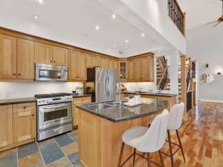 This stunning kitchen boasts beautiful wooden cabinetry and a spacious island with seating, perfect for entertaining.
