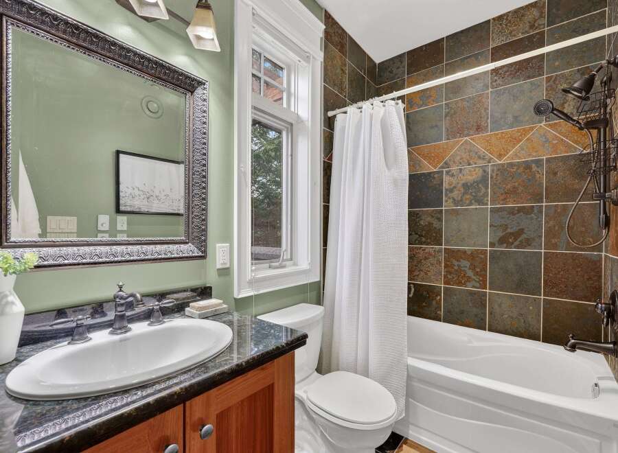 Step into a beautifully designed bathroom featuring a stylish vanity with a sleek countertop and a large, ornate mirror.