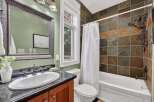 Step into a beautifully designed bathroom featuring a stylish vanity with a sleek countertop and a large, ornate mirror.