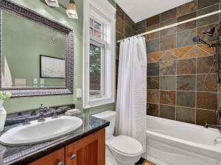 Step into a beautifully designed bathroom featuring a stylish vanity with a sleek countertop and a large, ornate mirror.
