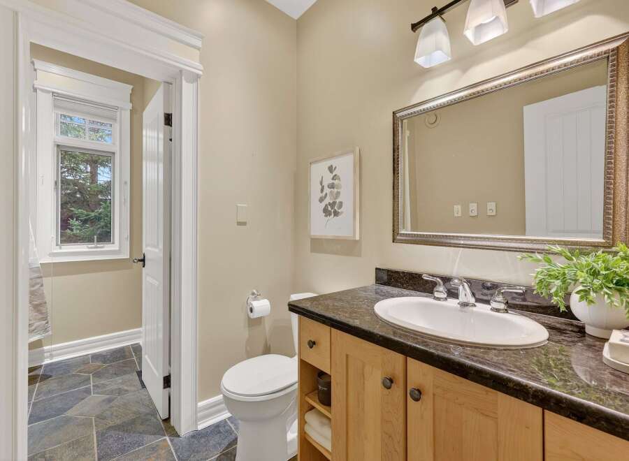 Step into this beautifully designed bathroom, featuring a stylish vanity with ample storage and a sleek countertop.