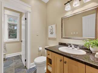 Step into this beautifully designed bathroom, featuring a stylish vanity with ample storage and a sleek countertop.