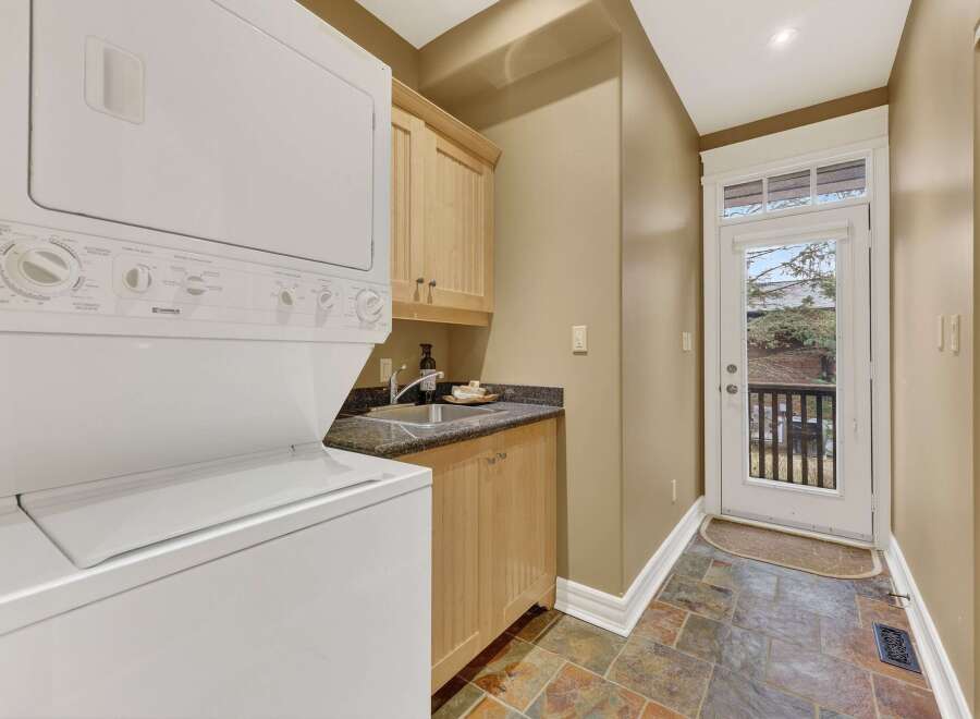 This laundry room features a stacked washer and dryer, maximizing space and efficiency.