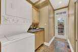 This laundry room features a stacked washer and dryer, maximizing space and efficiency.