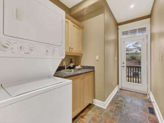 This laundry room features a stacked washer and dryer, maximizing space and efficiency.