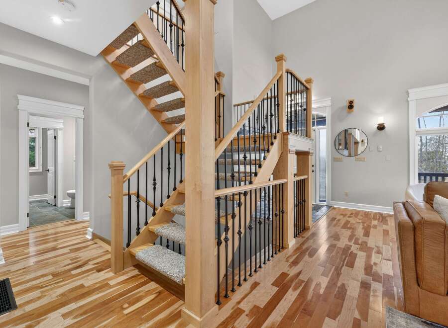 Step into luxury with this stunning home featuring a grand staircase with wooden steps and elegant black iron railings.