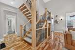 Step into luxury with this stunning home featuring a grand staircase with wooden steps and elegant black iron railings.