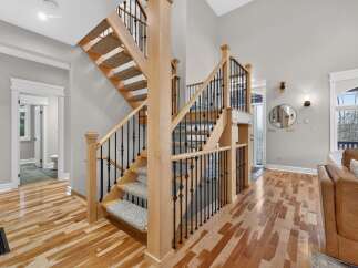 Step into luxury with this stunning home featuring a grand staircase with wooden steps and elegant black iron railings.