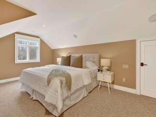 This cozy bedroom features a comfortable bed with soft bedding and decorative pillows, creating a relaxing atmosphere.