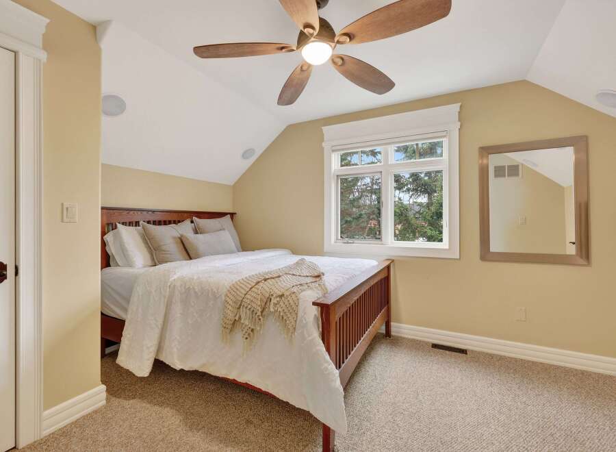 This inviting bedroom features a cozy ambiance with its neutral color palette and plush carpeting.