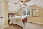This inviting bedroom features a cozy ambiance with its neutral color palette and plush carpeting.