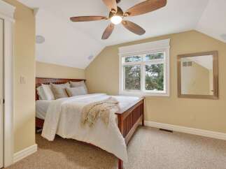 This inviting bedroom features a cozy ambiance with its neutral color palette and plush carpeting.