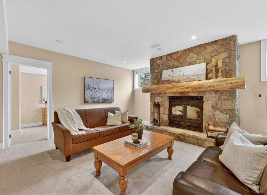 Step into luxury with this stunning living room featuring a cozy fireplace and elegant leather sofas.