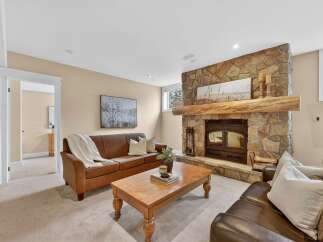Step into luxury with this stunning living room featuring a cozy fireplace and elegant leather sofas.