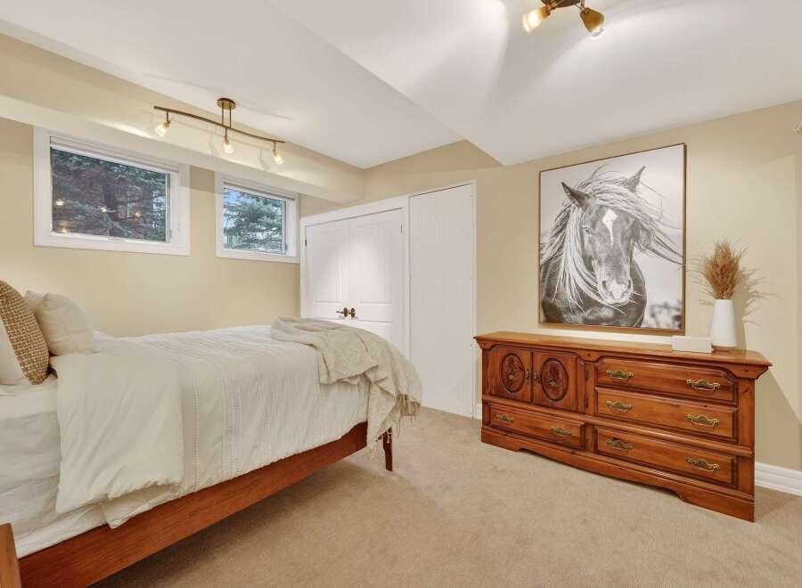 This inviting bedroom features a cozy ambiance with its neutral color palette and ample natural light.