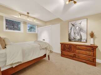 This inviting bedroom features a cozy ambiance with its neutral color palette and ample natural light.