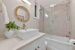This stunning bathroom boasts a modern design with a sleek, rectangular sink and a stylish, round mirror.
