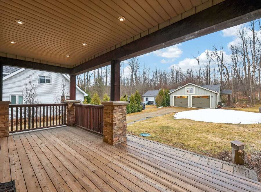 Enjoy the serene beauty of this property with a spacious wooden deck, perfect for relaxing and entertaining.