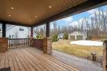 Enjoy the serene beauty of this property with a spacious wooden deck, perfect for relaxing and entertaining.