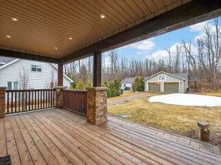 Enjoy the serene beauty of this property with a spacious wooden deck, perfect for relaxing and entertaining.