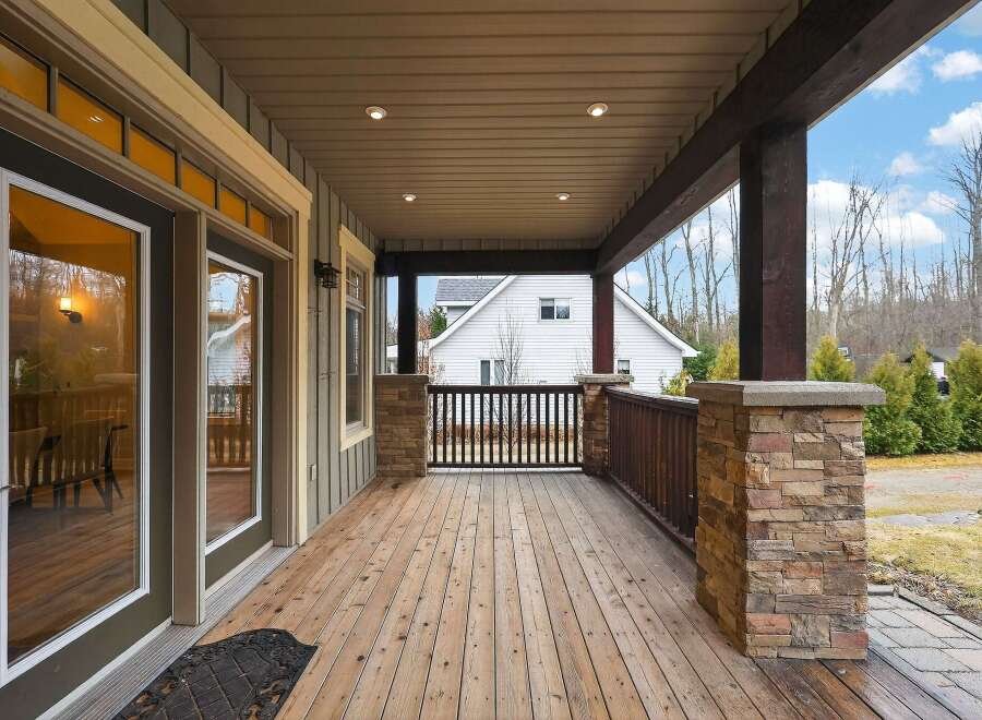 Step into luxury with this stunning home featuring a spacious covered porch, perfect for enjoying the outdoors in any weather.