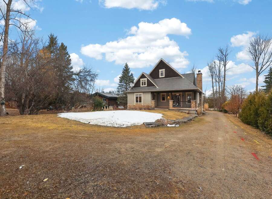 This stunning property boasts a charming exterior with a welcoming porch and a well-maintained yard.