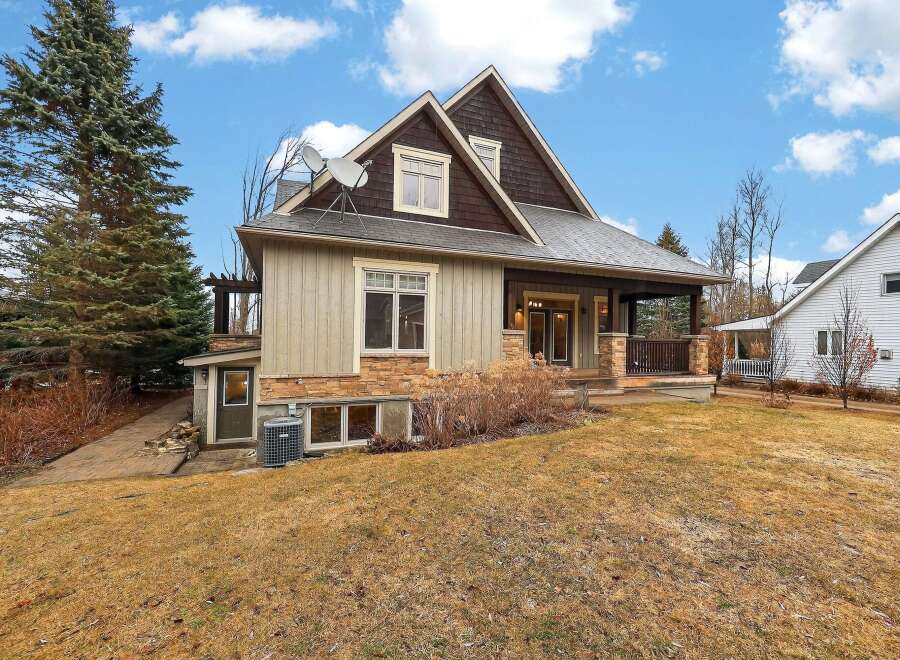 This stunning property boasts a beautiful exterior with a mix of natural stone and wood accents, creating a warm and inviting atmosphere.