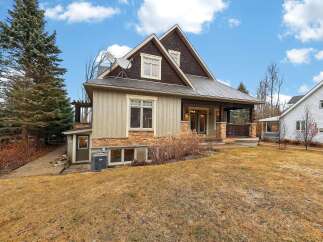 This stunning property boasts a beautiful exterior with a mix of natural stone and wood accents, creating a warm and inviting atmosphere.