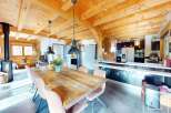 Experience the charm of this stunning property, featuring a spacious dining area with a rustic wooden table and elegant chairs.