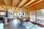 Experience the charm of this stunning property, featuring a spacious dining area with a rustic wooden table and stylish chairs.