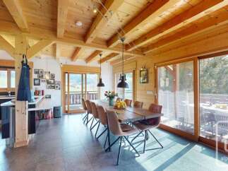 Experience the charm of this stunning property, featuring a spacious dining area with a rustic wooden table and stylish chairs.