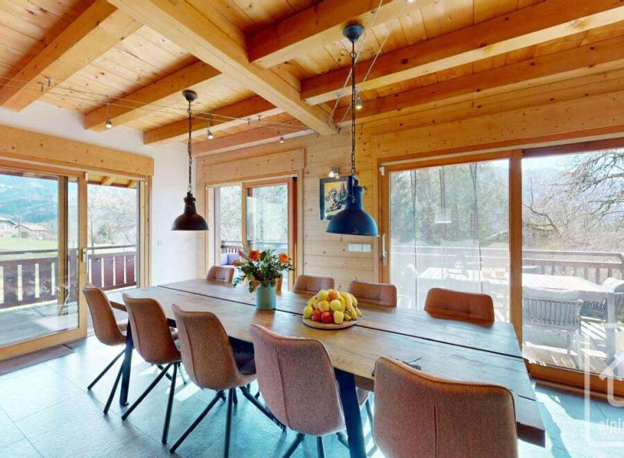 Experience the charm of this stunning property, featuring a spacious dining area with a rustic wooden table and stylish chairs.