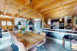 Experience the charm of this stunning property, featuring a spacious dining area with a rustic wooden table and elegant pendant lighting.