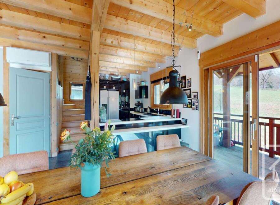 Experience the charm of this stunning property, featuring a rustic wooden dining table perfect for gatherings.