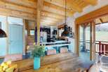 Experience the charm of this stunning property, featuring a rustic wooden dining table perfect for gatherings.