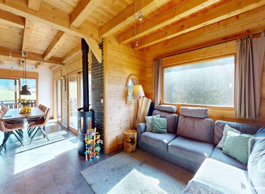 Step into this stunning chalet, showcasing a cozy living space with a fireplace and a comfortable sofa.