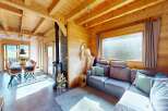 Step into this stunning chalet, showcasing a cozy living space with a fireplace and a comfortable sofa.
