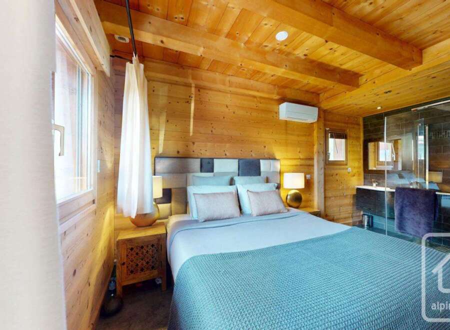Experience the warmth of this stunning bedroom, featuring beautiful wooden paneling and a cozy ambiance.