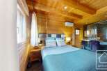Experience the warmth of this stunning bedroom, featuring beautiful wooden paneling and a cozy ambiance.