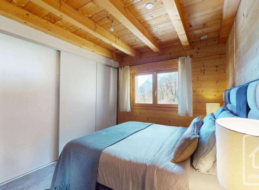 Discover the charm of this cozy bedroom, featuring a warm wooden ceiling and walls that create a rustic ambiance.