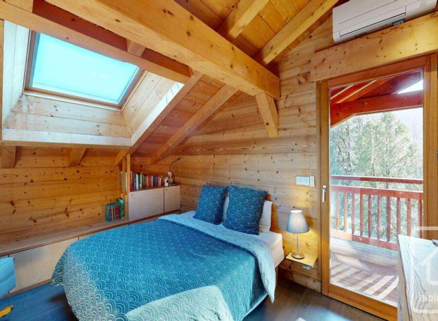 Discover the charm of this cozy bedroom, featuring a unique wooden ceiling and walls that exude warmth and character.